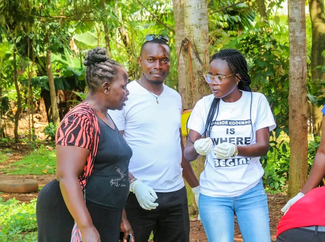 volunteers wearing protective gloves while discussing an anti-jigger treatment activity in a village.