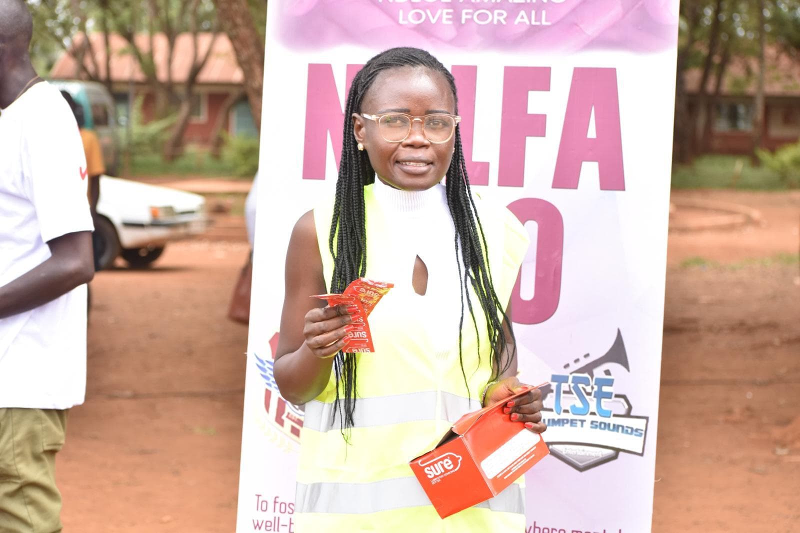 volunteer holding a box of condoms during a community health education and HIV prevention campaign in Siaya County, Kenya.
