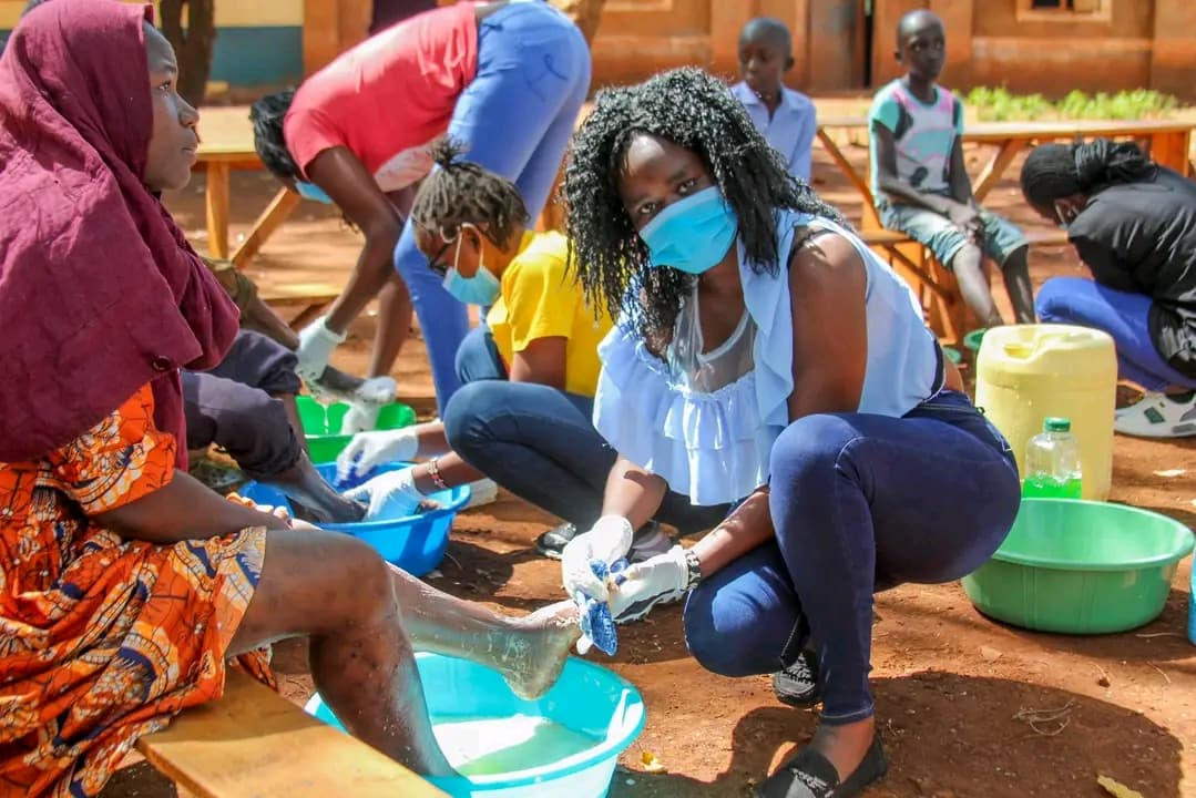 volunteer treating jiggers during a community health outreach in Umala Village, Siaya County, Kenya.