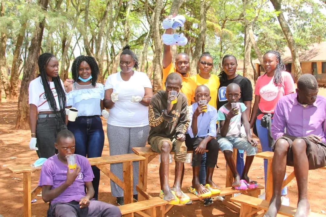 Children in Umala Village, Siaya County, enjoying snacks after receiving jigger treatment and new shoes during a NALFA CBO outreach programme.