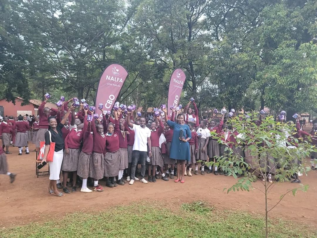 Girls at Awelo Junior Secondary School receiving sanitary pads from NALFA CBO during a menstrual hygiene awareness and donation programme in Siaya County, Kenya.