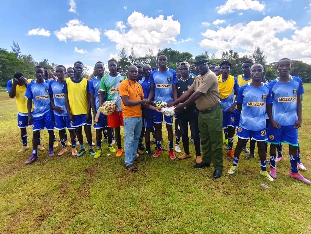Representatives of NALFA CBO presenting a football to Siaya Kenya Police FC during a sports development initiative in Siaya County, Kenya.
