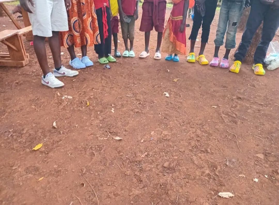 Happy children wearing new shoes donated by well-wishers during a NALFA CBO community outreach programme in Siaya County, Kenya.