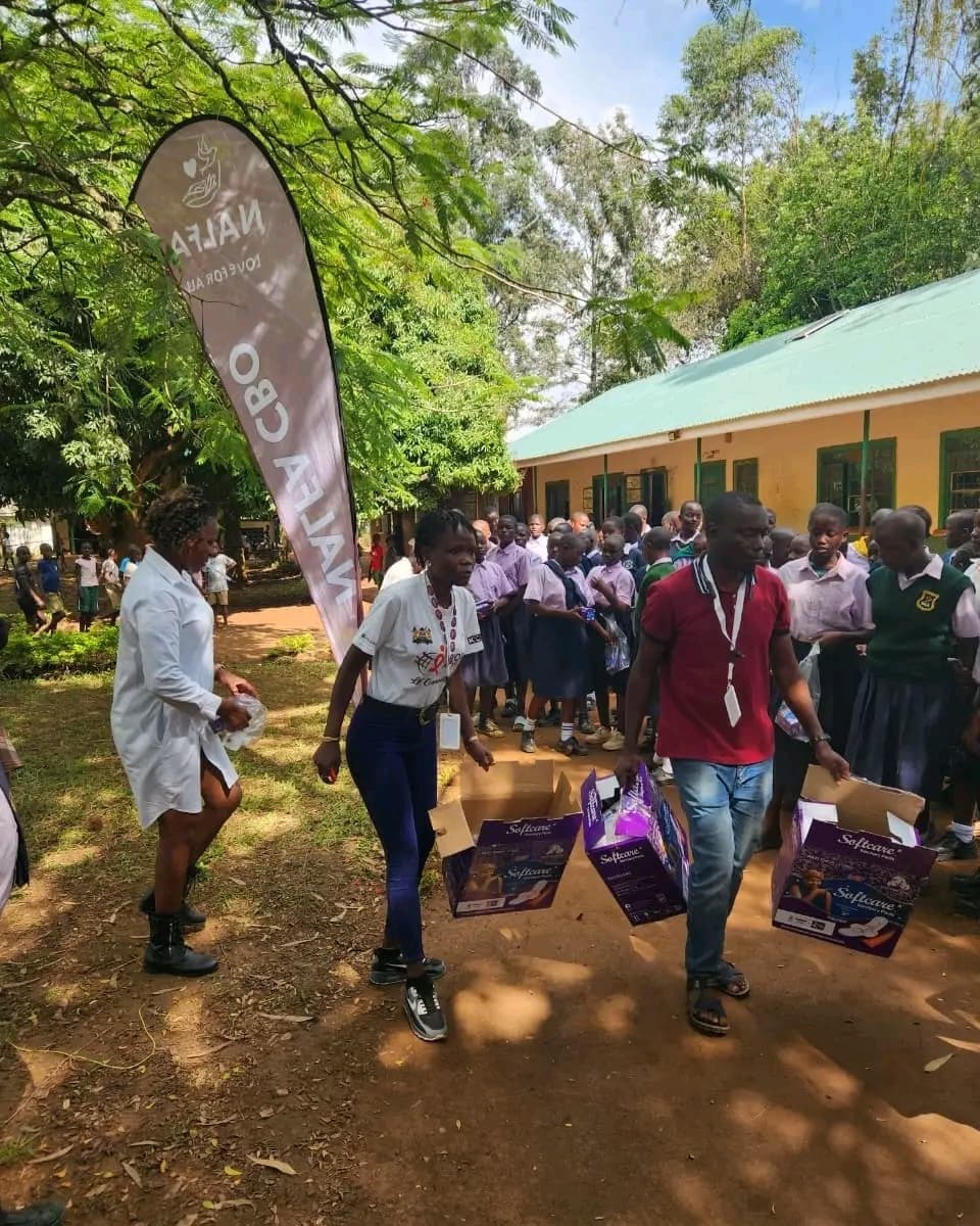 Girls at Ngunye Junior Secondary School in Ugenya receiving sanitary towels from NALFA CBO during a menstrual hygiene support programme.