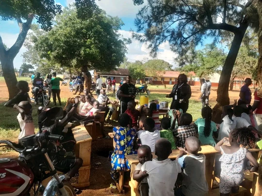 NALFA CBO volunteers talking with children attending the Ndege Siaya Super Cup Tournament after providing them with a free lunch and educational activities during the school holidays.