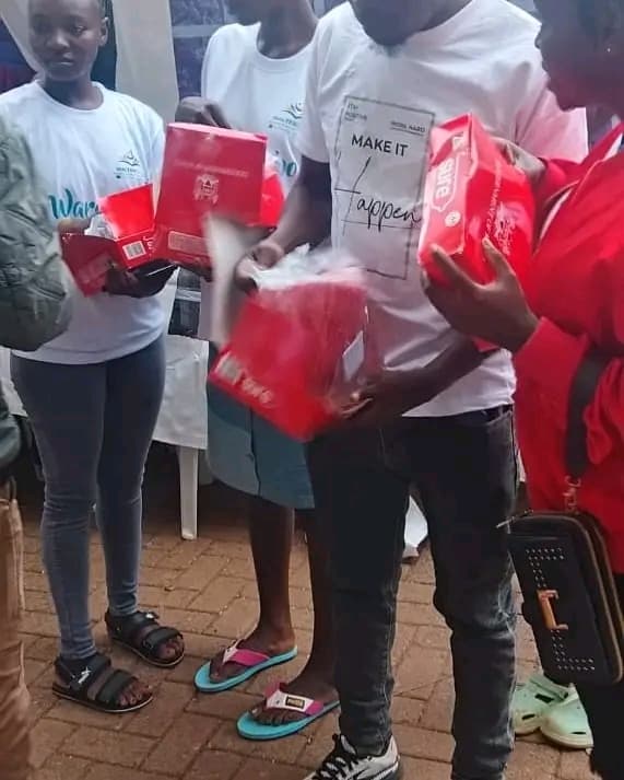 NALFA CBO volunteer distributing free condoms to participants during the Ndege Siaya Super Cup tournament in Siaya County, Kenya, promoting HIV prevention and sexual health awareness.
