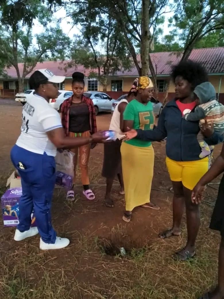 volunteer distributing free sanitary pads to girls and women during the Ndege Siaya Super Cup tournament in Siaya County, Kenya.