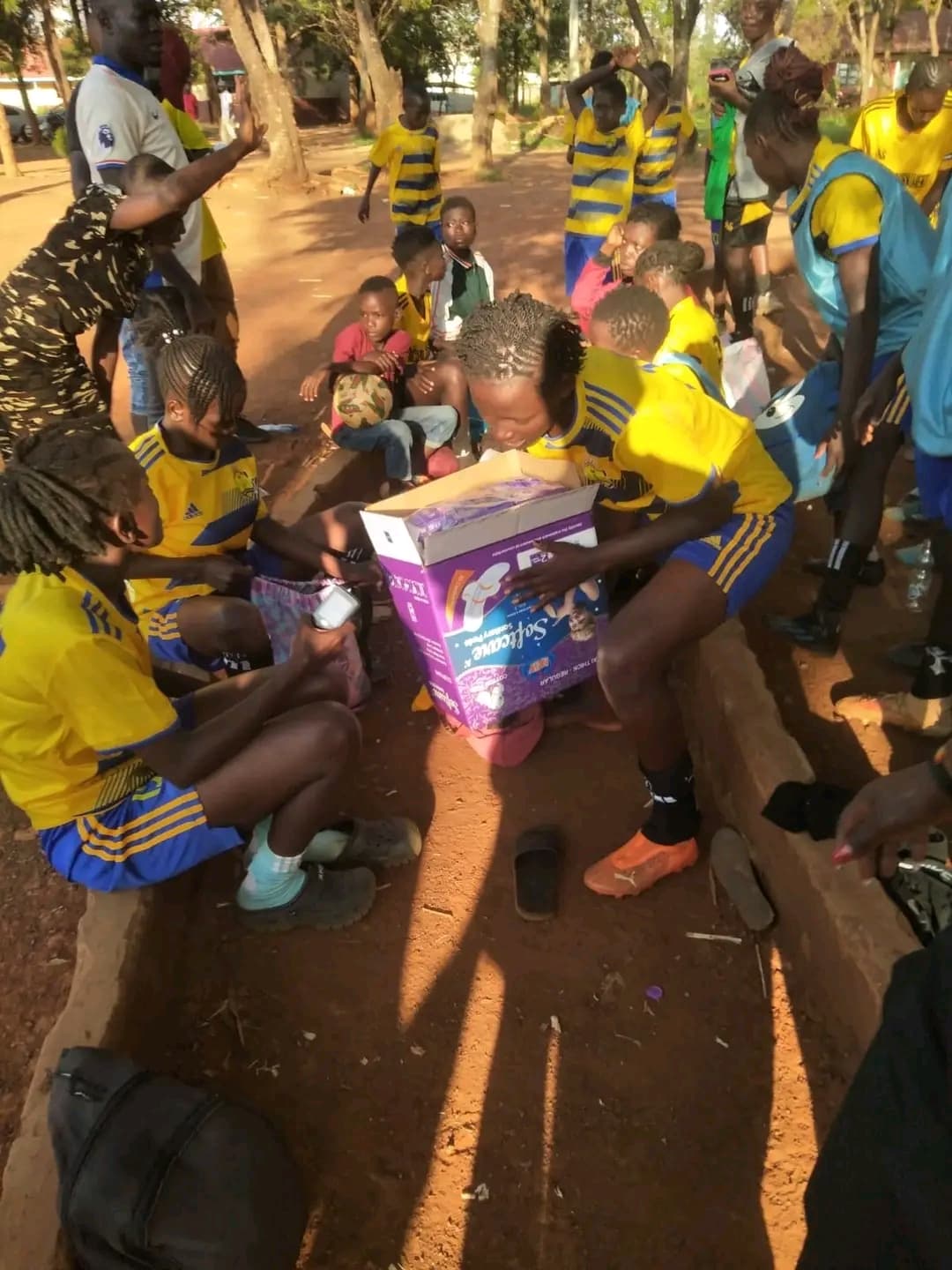 Players of Alego Usonga Queens Football Club receiving free sanitary pads from NALFA CBO after their match during the Ndege Siaya Super Cup tournament in Siaya County, Kenya.