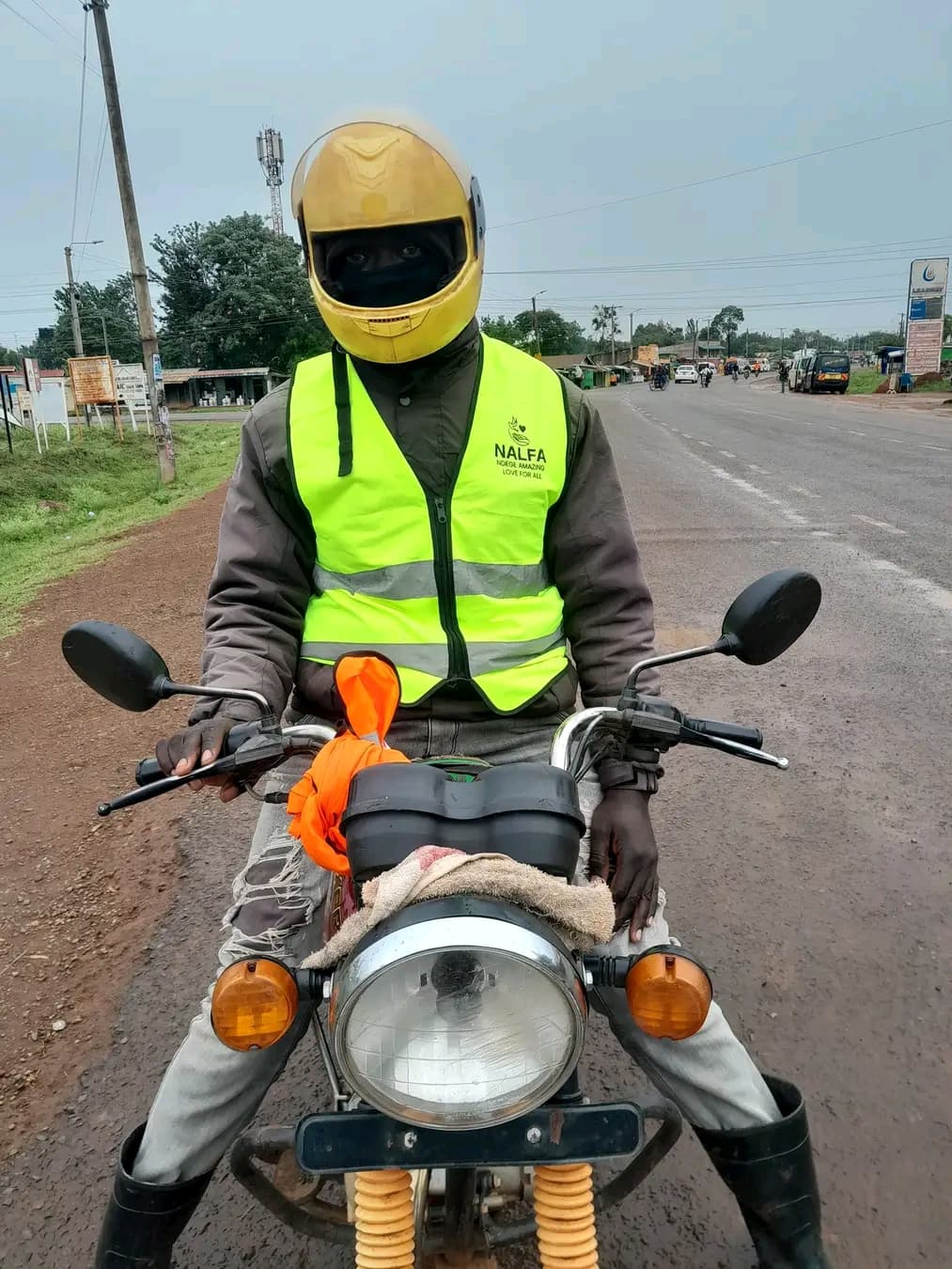 Boda boda rider wearing a NALFA CBO branded reflector to improve road safety and visibility.